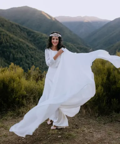 Novia vestida de blanco frente a un valle