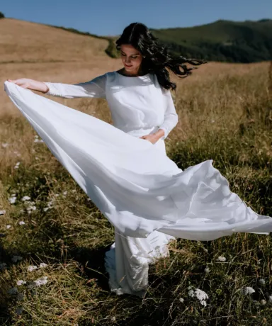 Novia en el campo moviendo la cola de su vestido