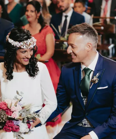 Pareja de novios sentados frente al altar durante la ceremonia