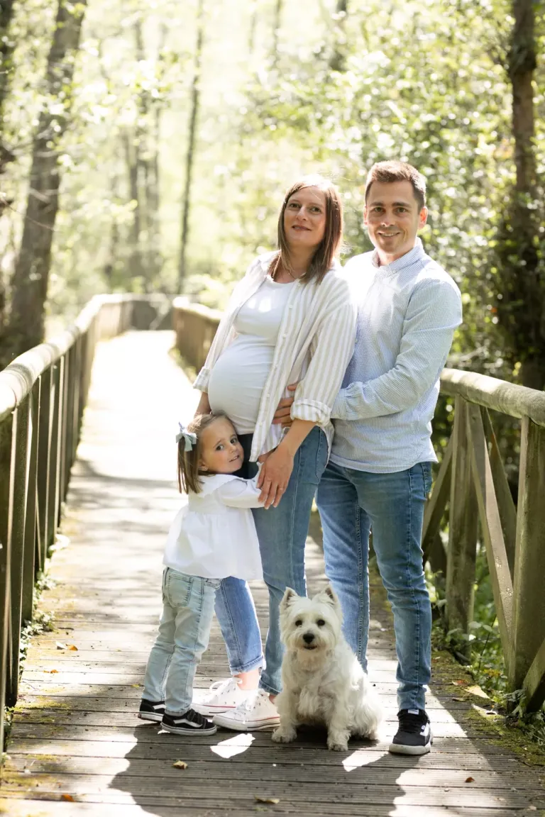 Familia con perro posando en un puente de madera