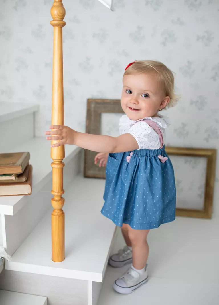 Niña con vestido azul en unas escaleras