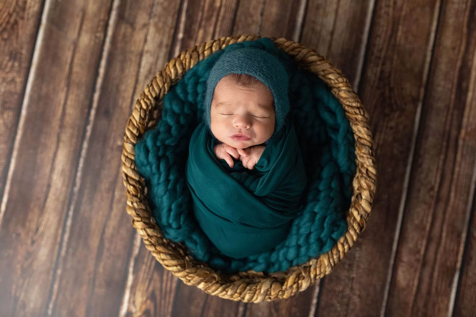 Recién nacido durmiendo envuelto en una manta azul con gorro